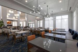 a dining room with tables and chairs and windows at Hilton Garden Inn Lynchburg in Lynchburg