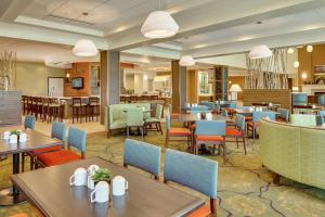 uma sala de jantar com mesas e cadeiras e um restaurante em Hilton Garden Inn Manhattan Kansas em Manhattan