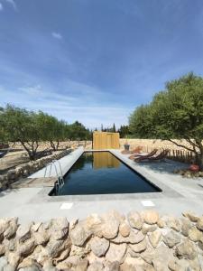 una piscina de agua en un patio con una pared de piedra en Mas des 4 Vents en Fitou