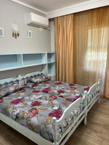 a bedroom with a bed with flowers on it at Jenny's Coastal escape in Nea Kallikrateia
