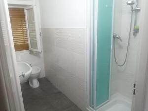 a bathroom with a shower with a toilet and a sink at Appartamento Riolunato (MO) in Riolunato