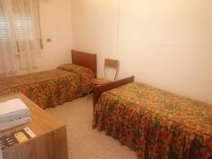 a hotel room with two beds and a table at Appartamento Riolunato (MO) in Riolunato