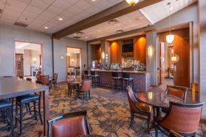 a restaurant with tables and chairs and a bar at DoubleTree by Hilton Bay City - Riverfront in Bay City