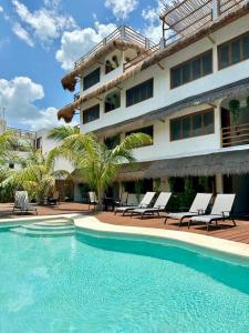 um hotel com piscina em frente a um edifício em La Casa del Sol Holbox em Ilha Holbox