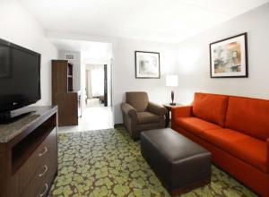 a living room with a couch and a television at Hilton Garden Inn Olathe in Olathe