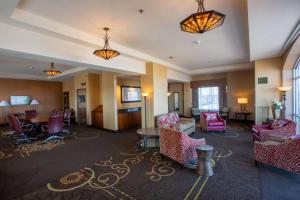 a hotel lobby with chairs and tables and lights at DoubleTree by Hilton Bay City - Riverfront in Bay City