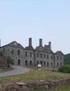 an old stone castle with a road in front of it at Les hortensias de Stéfanick in Mur-de-Bretagne