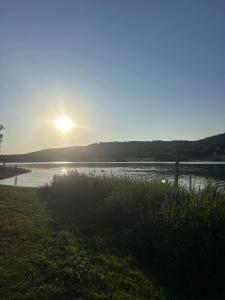 a sunset over a river with the sun setting at Les hortensias de Stéfanick in Mur-de-Bretagne