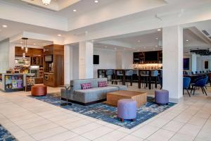 a lobby of a hotel with a couch and a bar at Hilton Garden Inn Kansas City/Kansas in Kansas City
