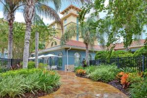 une maison bleue avec des palmiers devant elle dans l'établissement Hilton Garden Inn Orlando Lake Buena Vista, à Orlando