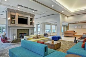 un grand salon avec des canapés et une cheminée dans l'établissement Hilton Garden Inn Orlando Lake Buena Vista, à Orlando