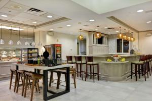 a kitchen with tables and chairs and a counter at Hilton Garden Inn Orlando Lake Buena Vista in Orlando