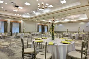 a ballroom with tables and chairs and a room filled with tables and chairsktop at Hilton Garden Inn Orlando Lake Buena Vista in Orlando +37 photos