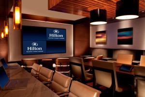 a restaurant with a bar with chairs and a television at Hilton McLean Tysons Corner in Tysons Corner +46 photos