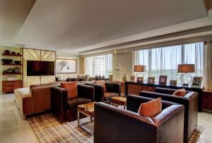 a large living room with couches and a flat screen tv at Hilton McLean Tysons Corner in Tysons Corner