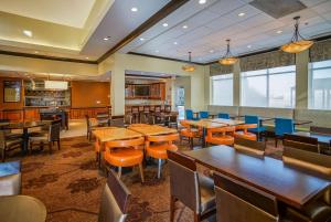 a restaurant with wooden tables and chairs and a bar at Hilton Garden Inn Kankakee in Kankakee