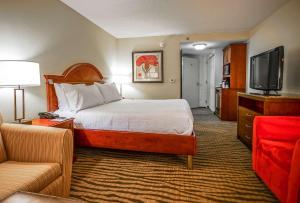 a hotel room with a bed and a flat screen tv at Hilton Garden Inn Kankakee in Kankakee