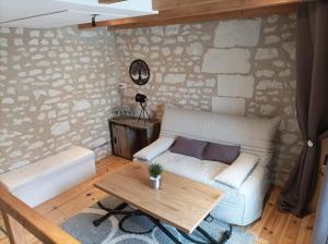 a living room with a couch and a table at L'instant Civray in Civray-sur-Esves