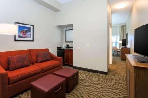 Hampton Inn Memphis-Southwind في ممفيس: غرفة معيشة مع أريكة وكرسي في غرفة في الفندق