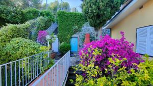einen Garten mit lila Blumen und einer blauen Tür in der Unterkunft La Terrazza sul Mare View in Porto Venere
