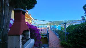einen Backsteinsteg neben einem Gebäude mit lila Blumen in der Unterkunft La Terrazza sul Mare View in Porto Venere
