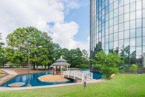 - un kiosque dans un parc à côté d'un grand bâtiment dans l'établissement Hilton Memphis, à Memphis