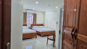 Un dormitorio con 2 camas y una silla. en 89 Hotel en Cao Bằng