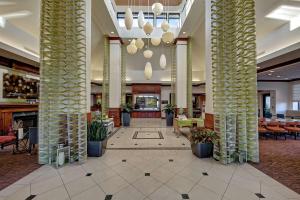 a lobby of a hotel with columns and tables at Hilton Garden Inn Memphis/Southaven in Southhaven