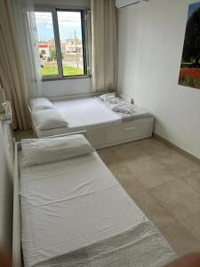 two beds in a room with a window at Casa Leukos Salento - con terrazza privata in Vignacastrisi +33 photos