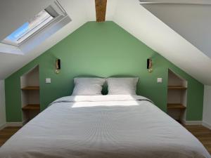 un letto in una camera con parete verde di La vertindus - Centre ville a Honfleur