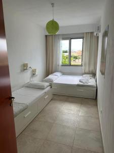 um quarto com 2 camas e uma janela em Casa Leukos Salento - con terrazza privata em Vignacastrisi