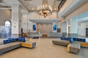 un vestíbulo con sofás y una lámpara de araña en Embassy Suites by Hilton Miami International Airport en Miami