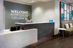 a woman standing at a welcome counter in a lobby at Hampton Inn & Suites Country Club Plaza in Kansas City