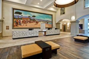 a lobby with a large painting on the wall at Embassy Suites by Hilton Milpitas Silicon Valley in Milpitas