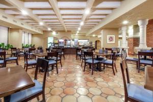 a dining room with wooden tables and chairs at Embassy Suites by Hilton Kansas City Plaza in Kansas City