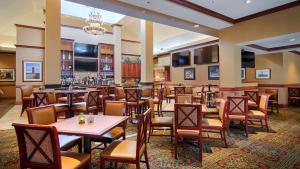 a restaurant with tables and chairs and a bar at Hilton Garden Inn Milwaukee Northwest Conference Center in Milwaukee