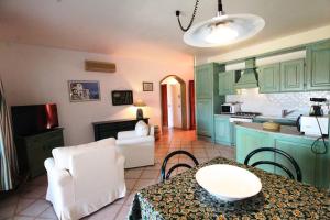 a kitchen with green cabinets and a table and chairs at Trilocale Portovenere Baia II in Cannigione