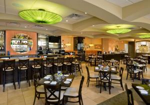 un restaurante con mesas y sillas y un bar en Hilton Garden Inn Mankato Downtown, en Mankato