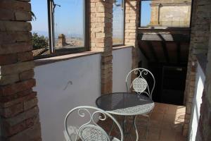 佩魯賈的住宿－LA CASA DEI POETI - C.I.R. 054039LOTUR19934，阳台设有窗户,配有一张桌子和两把椅子