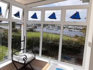 ein Erkerfenster mit Blick auf das Wasser und die Boote in der Unterkunft Ferry Lodge Cottage in Kilrush