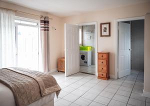 a bedroom with a bed and a door to a bathroom at Ferry Lodge Cottage in Kilrush