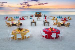 un restaurante en la playa con mesas y sillas en Hilton Marco Island Beach Resort and Spa en Marco Island