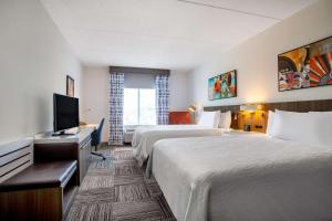 a hotel room with two beds and a flat screen tv at Hilton Garden Inn Nashville Smyrna in Smyrna