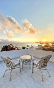 un patio con una mesa y dos sillas y el océano en Moustakas Beach Apartments, en Adamas