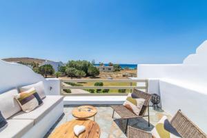 a living room with a table and chairs on a balcony at KŌRES Your Tinos Summer Retreat in Agios Ioannis Tinos
