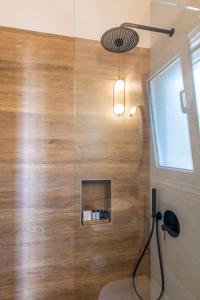 a bathroom with a shower with a wooden wall at KŌRES Your Tinos Summer Retreat in Agios Ioannis Tinos +28 photos