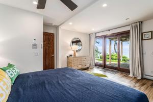 a bedroom with a blue bed and a large window at Beachside in Harbert