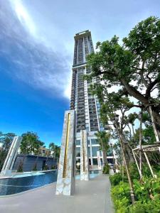 a tall building with a pool in front of it at Copacabana Beach Jomtien in Jomtien Beach