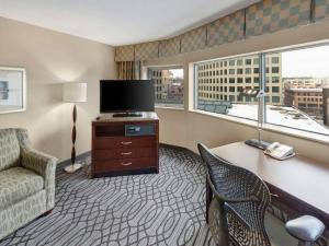 a hotel room with a desk with a television and a chair at DoubleTree by Hilton St Paul Downtown in Saint Paul