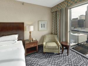 een hotelkamer met een bed, een stoel en een raam bij DoubleTree by Hilton St Paul Downtown in Saint Paul